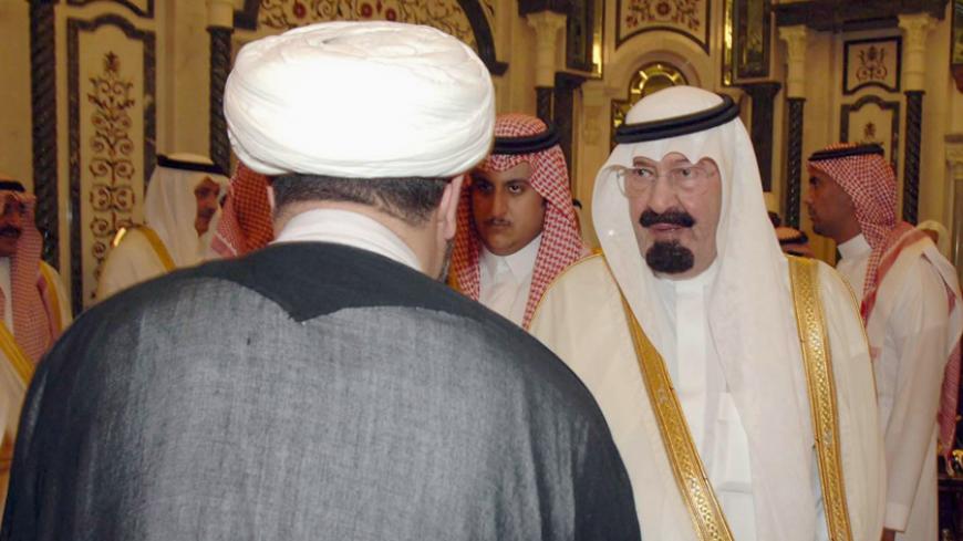 Saudi Arabia's King Abdullah (R) welcomes an Iraqi Shiite cleric at the Royal Palace in the Moslem holy city of Mecca. October 21, 2006. Iraqi Shi'ite and Sunni clerics meeting in Mecca called on Friday for an end to sectarian violence that many fear could lead to civil war in Iraq.  REUTERS/Saudi News Agency/Handout (SAUDI ARABIA) - RTR1IJKP