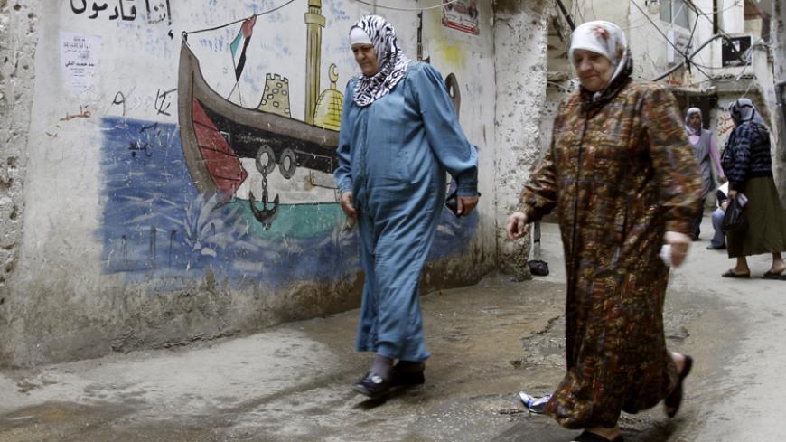 Palestinian women walk in an alley in Shatila refugee camp near Beirut May 23, 2007. The Lebanese army is trying to crush Fatah al-Islam, a militant group led by a Palestinian but with little or no support among Lebanon's Palestinian refugee population of 400,000. Dozens of people have died in three days of fighting. REUTERS/Sharif Karim (LEBANON) - RTR1Q072