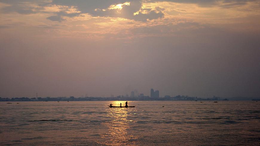 A wooden pirogue sails at dusk on the Congo River against the backdrop of high rises in the Democratic Republic of Congo's capital Kinshasa, March 7, 2010. Picture taken March 7, 2010. REUTERS/Katrina Manson (DEMOCRATIC REPUBLIC OF CONGO - Tags: SOCIETY ENVIRONMENT CITYSCAPE) - RTR2BDRC
