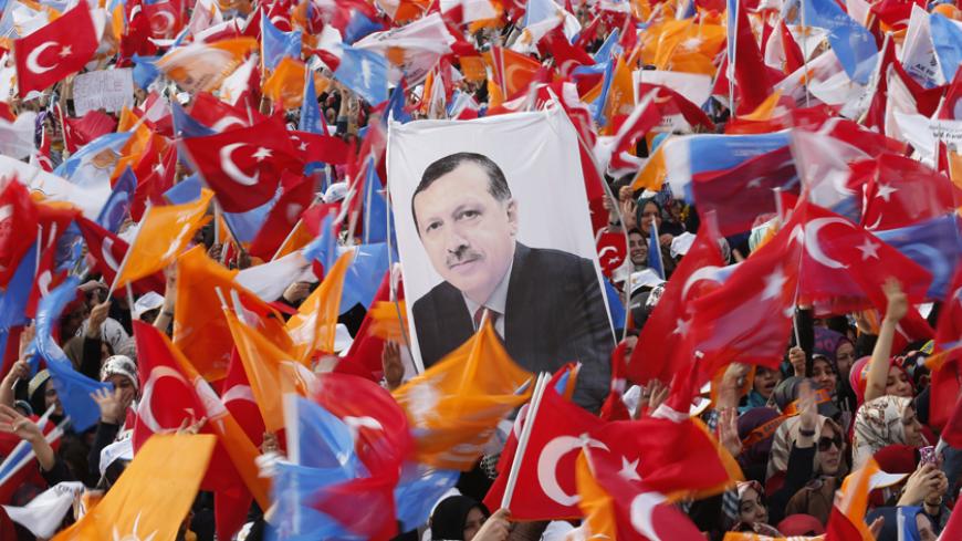 Supporters hold up a portrait of Turkey's Prime Minister Tayyip Erdogan while waving Turkish and AK Party (AKP) flags during an election rally in Istanbul March 23, 2014. Erdogan, rallying hundreds of thousands of cheering supporters in Istanbul, said on Sunday that political enemies accusing him of corruption would be crushed by their own immorality. REUTERS/Murad Sezer (TURKEY - Tags: POLITICS ELECTIONS) - RTR3I96X