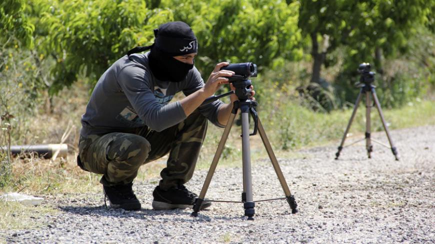 A rebel fighter prepares cameras ahead of firing mortars towards forces loyal to Syria's President Bashar al-Assad in the village of Tshalma near the Armenian Christian town of Kasab May 26, 2014. REUTERS/Alaa Khweled (SYRIA - Tags: POLITICS CIVIL UNREST CONFLICT) - RTR3QYIQ