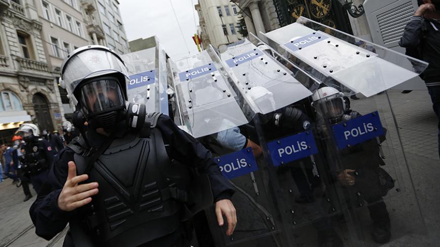 Turkish riot police use their shields to protect themselves as they clash with demonstrators during a protest in central Istanbul May 31, 2014. On the first anniversary of nationwide protests that shook Prime Minster Tayyip Erdogan's rule, barely a thousand anti-government demonstrators marched in Istanbul on Saturday. Outnumbered by riot police, they were soon sent scurrying into side streets by tear gas and water cannon. Their scant numbers were an illustration of Erdogan's tightening grip on power despit