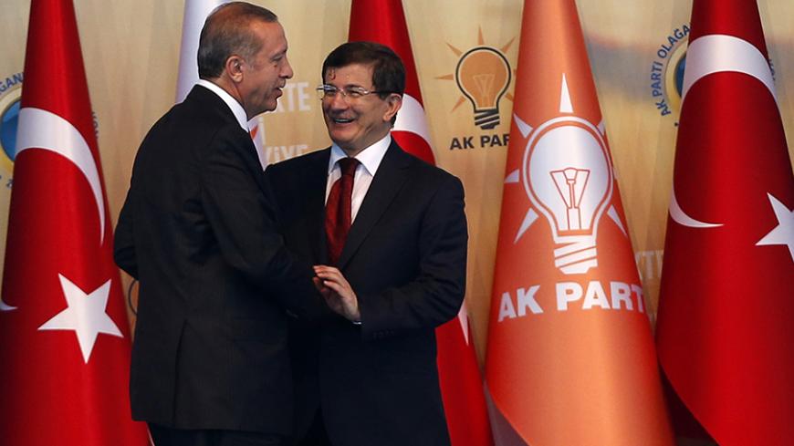 Turkey's President-elect Tayyip Erdogan (L) shakes hands with incoming prime minister Ahmet Davutoglu during the Extraordinary Congress of the ruling AK Party (AKP) in Ankara August 27, 2014. Erdogan said on Wednesday he would ask incoming prime minister Ahmet Davutoglu to form a new government on Thursday, and a new cabinet of ministers would be announced the following day. REUTERS/Umit Bektas (TURKEY - Tags: POLITICS) - RTR43YZA