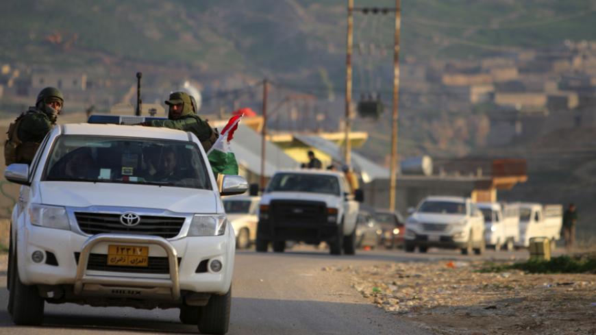 Kurdish peshmerga fighters ride their vehicles along a road on Mount Sinjar December 22, 2014. On Sunday, Kurdish and Yazidi fighters battled to take the Sinjar back from Islamic State after breaking a months-long siege of the mountain above it. Seizing the town would restore the majority of territory Iraq's Kurds lost in Islamic State's surprise offensive in August. Picture taken December 22, 2014. REUTERS/Stringer (IRAQ - Tags: POLITICS CIVIL UNREST CONFLICT) - RTR4J2WC