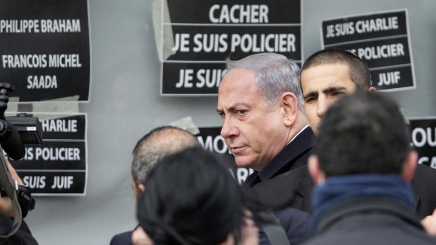 Israel's Prime Minister Benjamin Netanyahu arrives at the Hyper Cacher kosher supermarket January 12, 2015 near the Porte de Vincennes in Paris, where four hostages were killed on Friday. On the wall (L) we can read the four names among the 17 victims of the shootings by gunmen from last week's terror attacks in France along with "I am Hyper Cacher, I am a Policeman, I am Charlie."  Jewish schools and synagogues in France have been promised extra protection, by the army if necessary, after killings by Islam