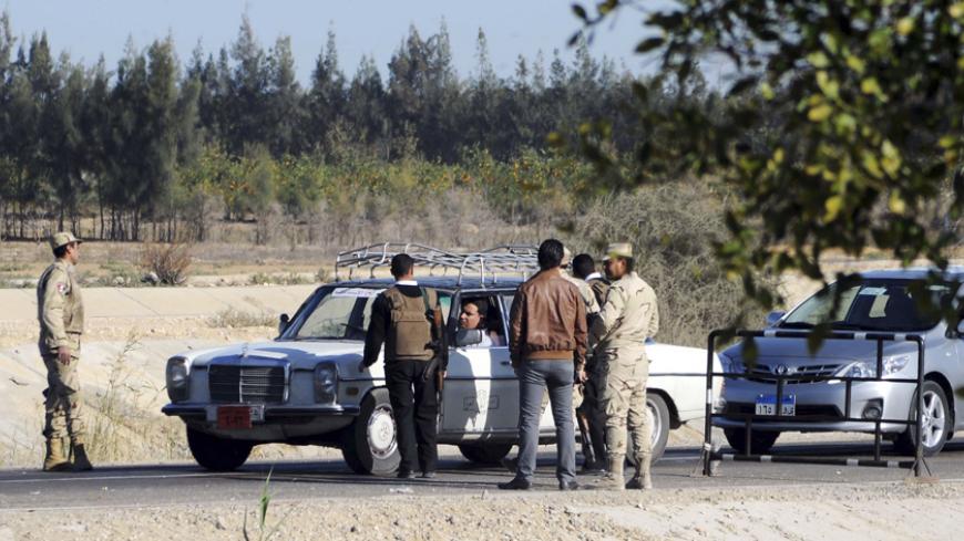 Egyptian security personnel check cars at a checkpoint near the site, where separate attacks on security forces in North Sinai on Thursday killed 30 people, in Arish, North Sinai, Egypt, January 31, 2015.  President Abdel Fattah al-Sisi said on Saturday that Egypt faces a long, hard battle against militancy, days after one of the bloodiest attacks on security forces in years. On Thursday night, four separate attacks on security forces in North Sinai were among the worst in the country in years. Islamic Stat