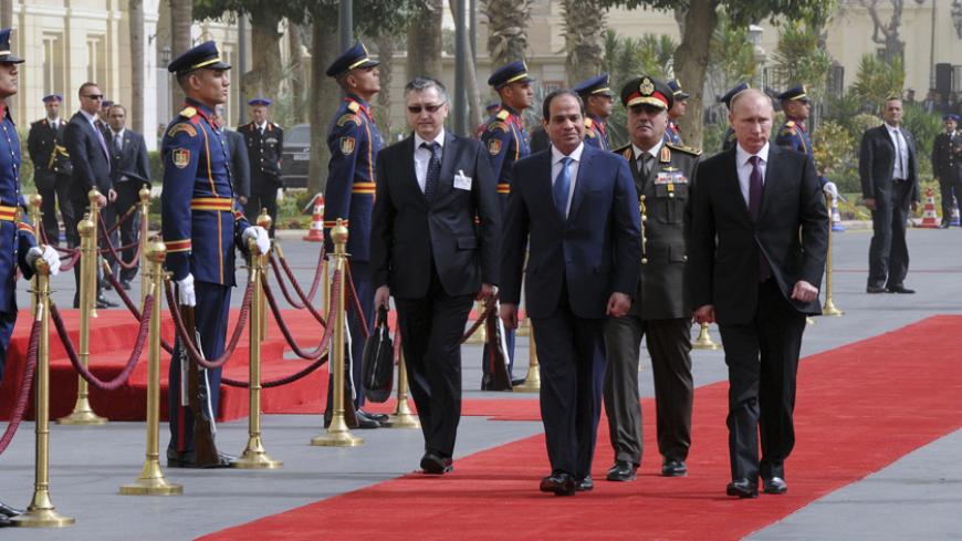 Russia's President Vladimir Putin (R) and Egyptian President Abdel Fattah al-Sisi (C) attend a welcoming ceremony upon Putin's arrival in Cairo February 10, 2015. REUTERS/Mikhail Klimentyev/RIA Novosti/Kremlin (EGYPT  - Tags: POLITICS) ATTENTION EDITORS - THIS IMAGE HAS BEEN SUPPLIED BY A THIRD PARTY. IT IS DISTRIBUTED, EXACTLY AS RECEIVED BY REUTERS, AS A SERVICE TO CLIENTS - RTR4P0YO
