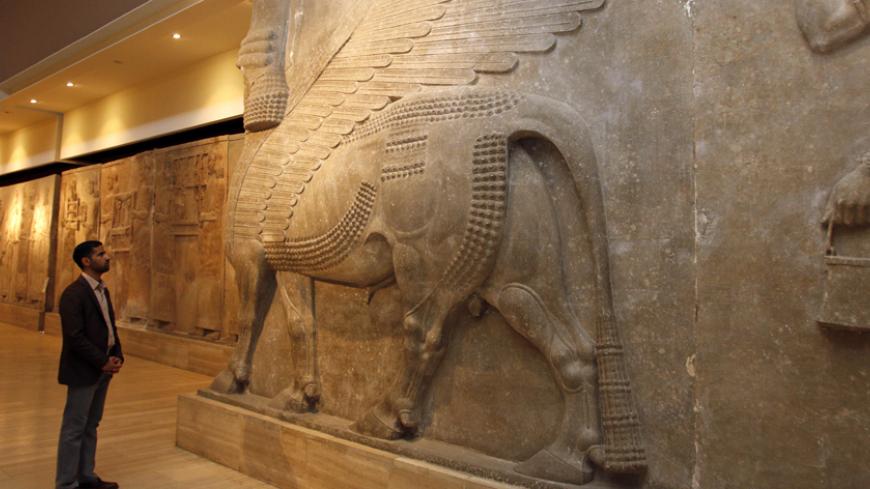 A man looks at ancient Assyrian human-headed winged bull statues at the Iraqi National Museum in Baghdad February 28, 2015. REUTERS/Khalid al-Mousily  (IRAQ - Tags: POLITICS) - RTR4RIZ3