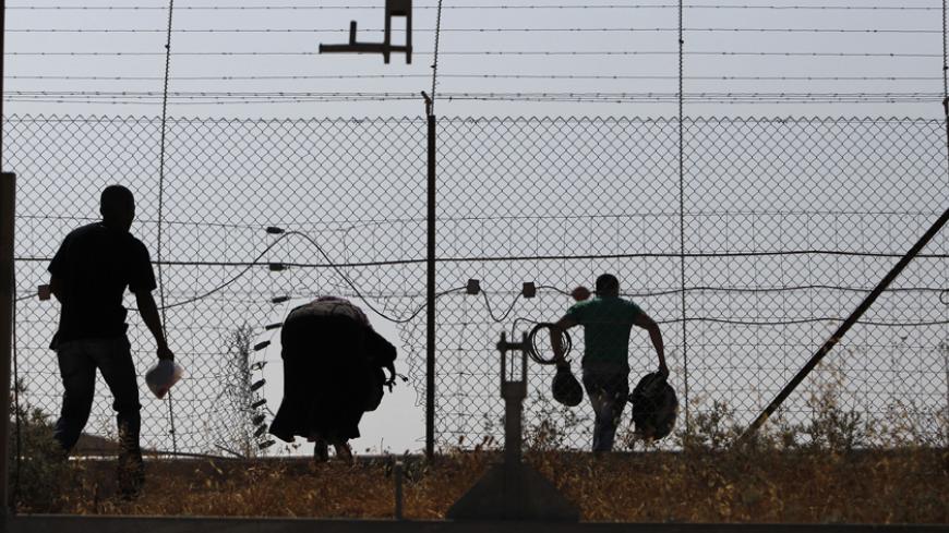 Palestinian labourers from the West Bank illegally cross Israel's controversial barrier in the southern West Bank June 22, 2013. There are two ways for Palestinian workers to cross into Israel every day. Those with work permits can pass through a military checkpoint. Those without have to find a way through the separation barrier, which is made up of mostly fences and some cement walls, snaking its way through the West Bank. Those caught entering illegally risk a fine or imprisonment. Both ways are time con