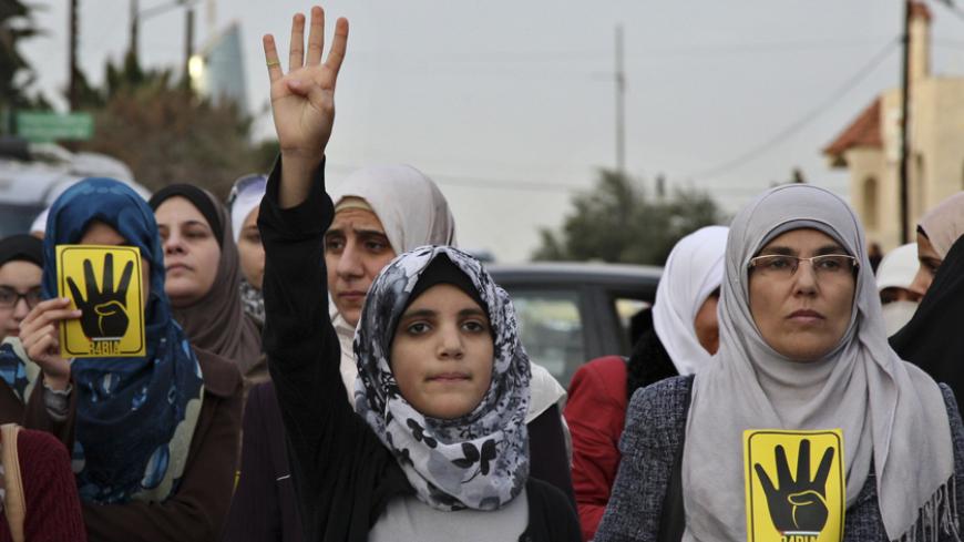 Jordanian Muslim Brotherhood protesters make the 'four-fingered salute' during a protest against the Egyptian Defense Minister Abdel Fattah al-Sissi as they mark the third anniversary of revolution, in front of the Egyptian embassy in Amman January 25, 2014. REUTERS/Majed Jaber (JORDAN - Tags: POLITICS CIVIL UNREST) - RTX17U9I