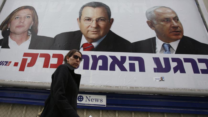 A pedestrian walks under a Labour party campaign billboard depicting party leader and Defence Minister Ehud Barak (C), Likud party leader Benjamin Netanyahu (R) and Foreign Minister Tzipi Livni in Ramat Gan near Tel Aviv February 8, 2009. Surveys predict a narrow win in Tuesday's vote for hawkish ex-premier Netanyahu, his comeback fuelled by the inconclusive wars in southern Lebanon and Gaza, formerly areas under Israel's control and now bastions of hostile Islamists. REUTERS/Gil Cohen Magen (ISRAEL) - RTXB