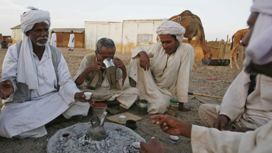 Men from the Baja tribe drink Gabana or  traditional coffee, in front of their huts in the Egyptian town of Shelatine, 1,060 km (659 miles) south of Cairo, April 22, 2009. REUTERS/Asmaa Waguih   (EGYPT SOCIETY TRAVEL) - RTXE9O4