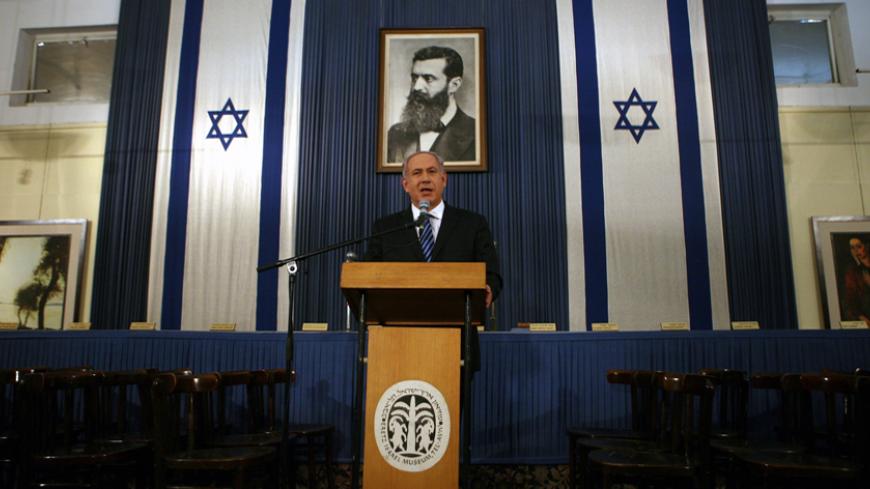 Israel's Prime Minister Benjamin Netanyahu speaks to the media while standing in front of a portrait of Theodore Herzl, the father of modern Zionism, during a visit to the Independence Hall in Tel Aviv October 14, 2010. The building was where Israel's declaration of independence was first read by its first Prime Minister David Ben-Gurion. REUTERS/Lior Mizrahi/Pool (ISRAEL - Tags: POLITICS) - RTXTG5P