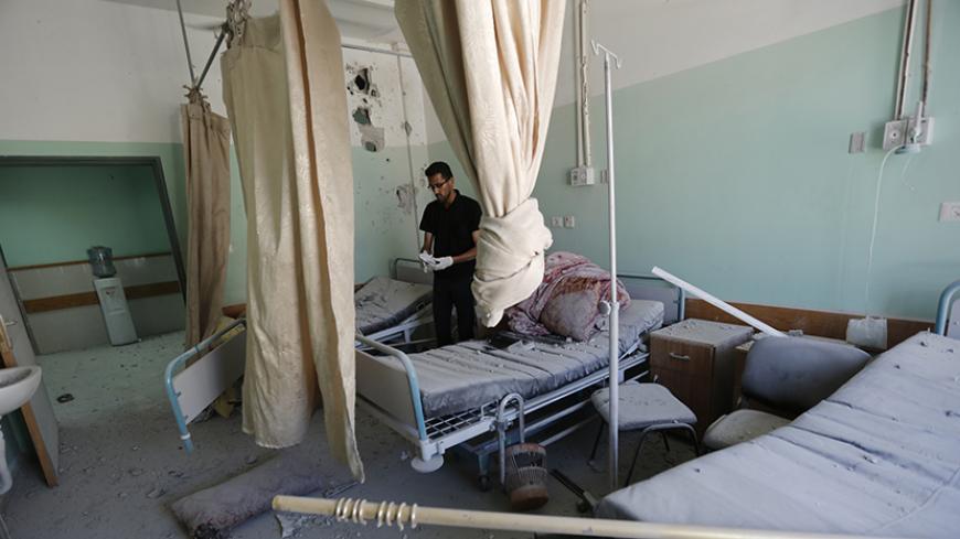 A Palestinian employee inspects damages at the Al-Aqsa Martyrs hospital in Deir al-Balah, in the central Gaza Strip, after the building was shelled by the Israeli army on July 21, 2014, killing five people and wounding at least 70. World efforts to end two weeks of deadly violence in and around Gaza stepped up a gear as the UN chief arrived in Cairo and the top US diplomat was awaited. AFP PHOTO / MOHAMMED ABED        (Photo credit should read MOHAMMED ABED/AFP/Getty Images)