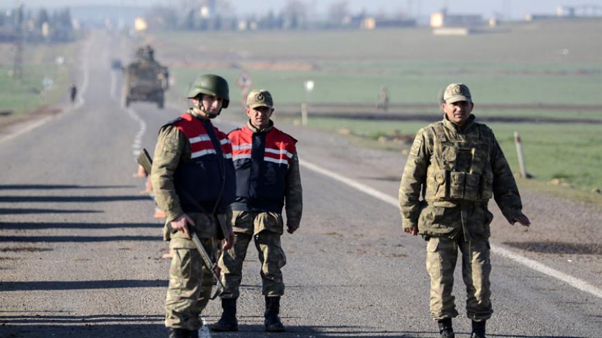 Turkish army soldiers take position on the road to the Mursitpinar crossing gate near the Syrian border on February 22, 2015 in Suruc, Sanliurfa province, during an operation to relieve the garrison guarding the Suleyman Shah mausoleum in northern Syria. The operation was jointly conducted by the intelligence organisation and the Turkish army, a few days after reports suggested that the tomb was besieged by jihadists belonging to the Islamic State (IS) group. AFP PHOTO/ILYAS AKENGIN        (Photo credit sho