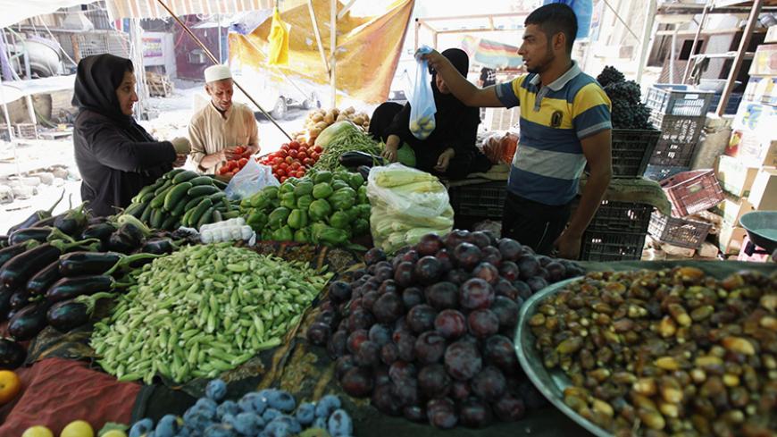 Residents buy vegetables in a market in Baghdad's Karrada district August 14, 2012. Iraq relies on imports from neighbours like Syria, Turkey and Iran for 95 percent of its consumer goods. Syria in particular is a key supplier of manufactured goods, fresh vegetables and fruit. But as an uprising there against President Bashar al-Assad grinds through its 17th month, the supply of Syrian goods to Iraq is slowly drying up as Syrian businesses are forced to close and trucks struggle to cross borders that have s