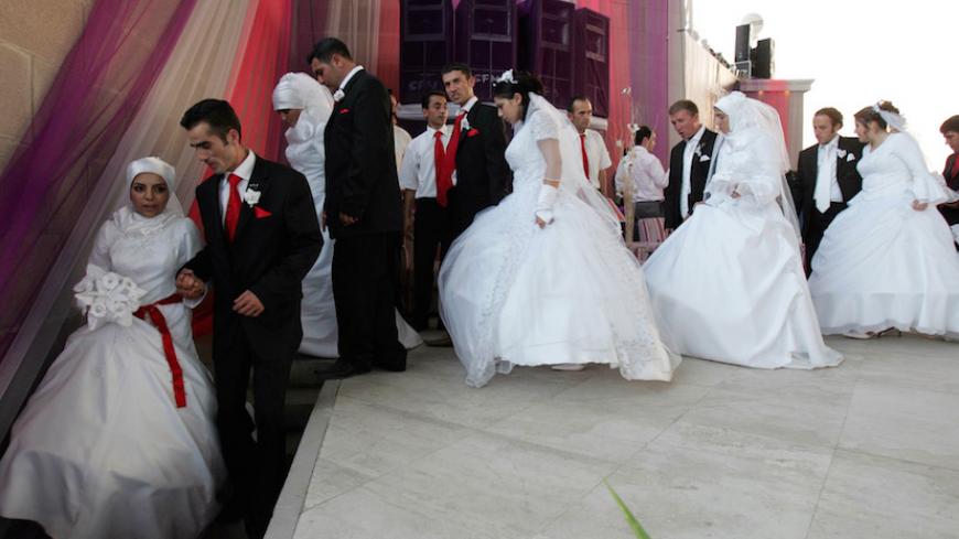 Brides and bridegrooms leave the stage during their wedding ceremony in Ankara, August 6, 2006. 206 couples married together with an annual ceremony organised by Ankara municipality. REUTERS/Umit Bektas  (TURKEY) - RTR1G5N0