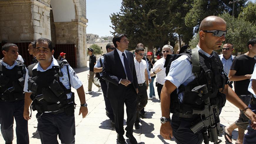 Israeli lawmaker Danny Danon (C), a deputy parliament speaker, is surrounded by police officers as he walks on the compound known to Muslims as al-Haram al-Sharif and to Jews as Temple Mount, in Jerusalem's Old City July 20, 2010. Danon, a lawmaker of Prime Minister Benjamin Netanyahu's right-wing party, on Tuesday visited the flashpoint religious site in Jerusalem revered by Jews and Muslims, a move that has sparked violence in the past. REUTERS/Ammar Awad (JERUSALEM - Tags: POLITICS RELIGION) - RTR2GKI0