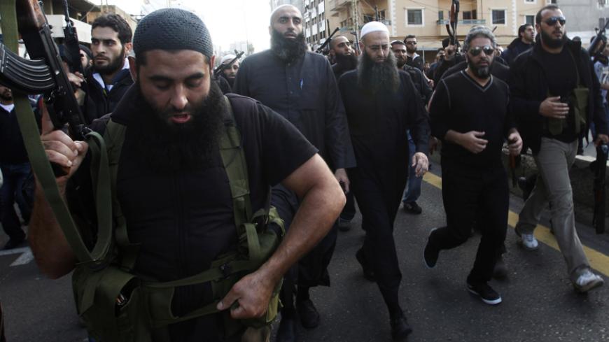 Armed supporters of Lebanon's Sunni Muslim Salafist leader Ahmad al-Assir (front row 3rd R) escort him and Lebanese singer Fadel Shaker (front row 2nd R) during the funeral of two of al-Assir's supporters, who died during Sunday's fighting with supporters of Lebanon's Hezbollah, in Sidon, southern Lebanon November 12, 2012. Three people were killed on Sunday when fighting broke out in the Lebanese coastal city of Sidon between followers of al-Assir and supporters of the Lebanese Shi'ite guerrilla movement H