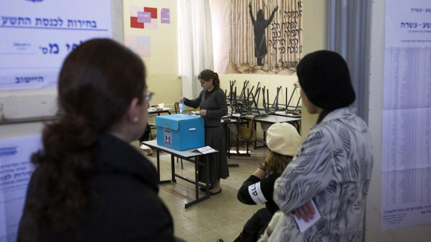 Ultra-Orthodox Jewish women watch as another woman casts her ballot for the parliamentary election at a polling station in Jerusalem January 22, 2013. Israelis voted on Tuesday in an election that is expected to see Prime Minister Benjamin Netanyahu win a third term in office, pushing the Jewish state further to the right, away from peace with the Palestinians and towards a showdown with Iran. REUTERS/Ronen Zvulun (JERUSALEM - Tags: POLITICS ELECTIONS) - RTR3CSE6