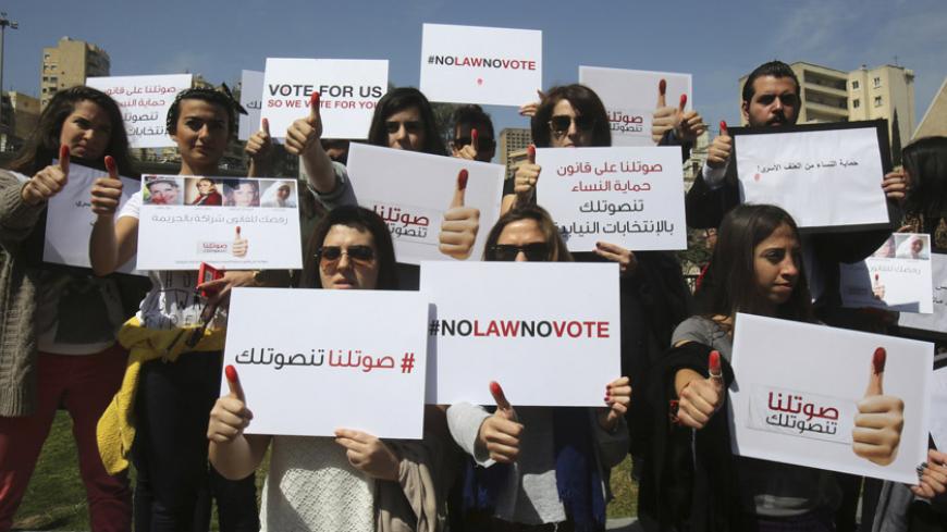 Activists hold up their red-inked thumbs and carry banners as they pose for the media during a sit-in near the parliament and in front of the U.N. headquarters in Beirut April 1, 2014. The activists held the rally on Tuesday to demand politicians approve Lebanon's first law of protecting women from domestic violence.   REUTERS/Sharif Karim   (LEBANON - Tags: POLITICS CIVIL UNREST SOCIETY) - RTR3JG2D