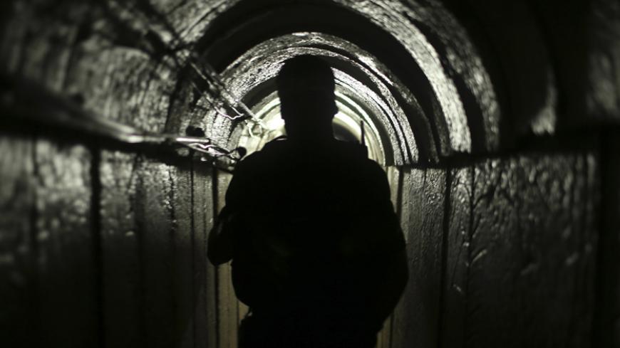 A Palestinian fighter from the Izz el-Deen al-Qassam Brigades, the armed wing of the Hamas movement, is seen inside an underground tunnel in Gaza August 18, 2014. A rare tour that Hamas granted to a Reuters reporter, photographer and cameraman appeared to be an attempt to dispute Israel's claim that it had demolished all of the Islamist group's border infiltration tunnels in the Gaza war. Picture taken August 18, 2014. To match Exclusive MIDEAST-GAZA/TUNNELS             REUTERS/Mohammed Salem (GAZA - Tags: 