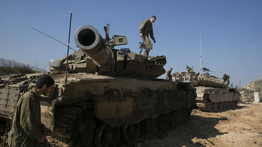 Israeli soldiers stand atop tanks near the border with Lebanon January 20, 2015. An Iranian general killed in an Israeli air strike in Syria was not its intended target and Israel believed it was attacking only low-ranking guerrillas, a senior security source said on Tuesday. Troops and civilians in northern Israel are on heightened alert and Israel has deployed an Iron Dome rocket interceptor unit near the Syrian border. REUTERS/Baz Ratner (ISRAEL - Tags: MILITARY POLITICS) - RTR4M69S