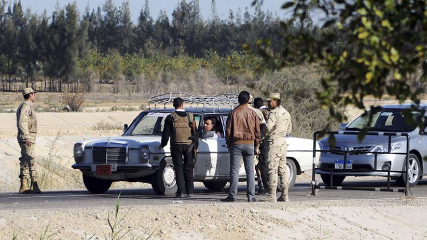 Egyptian security personnel check cars at a checkpoint near the site, where separate attacks on security forces in North Sinai on Thursday killed 30 people, in Arish, North Sinai, Egypt, January 31, 2015.  President Abdel Fattah al-Sisi said on Saturday that Egypt faces a long, hard battle against militancy, days after one of the bloodiest attacks on security forces in years. On Thursday night, four separate attacks on security forces in North Sinai were among the worst in the country in years. Islamic Stat