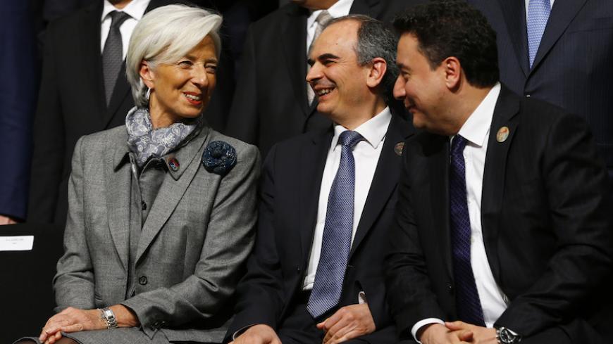 International Monetary Fund (IMF) Managing Director Christine Lagarde (L) chats with Turkey's Deputy Prime Minister Ali Babacan (R) and Turkish Central Bank Governor Erdem Basci (C) during a family photo session at the G20 finance ministers and central bank governors meeting in Istanbul February 10, 2015. The United States urged a meeting of the Group of 20 leading economies not to resort to currency devaluations to boost exports, while a draft communique gave a gloomy assessment on Tuesday of the outlook f