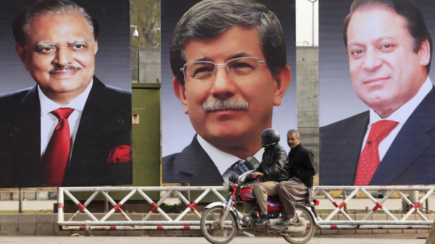 Men ride a motorcycle past giant portraits of (L-R) Pakistan's President Mamnoon Hussain,Turkish Prime Minister Ahmet Davutoglu, and Pakistan's Prime Minister Nawaz Sharif, displayed along a road in Islamabad February 17, 2015. Davutoglu is in Pakistan on a two-day visit until February 18. REUTERS/Faisal Mahmood (PAKISTAN - Tags: POLITICS MILITARY) - RTR4PVJ2