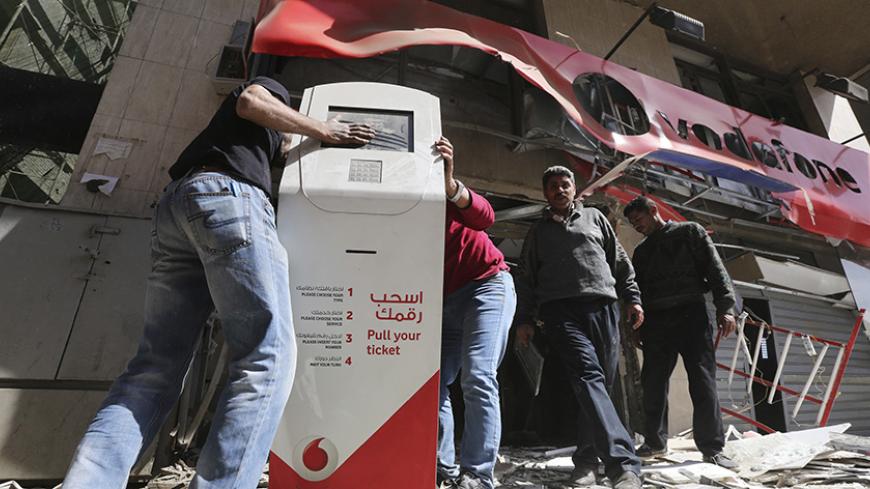 Workers clear debris outside a Vodafone branch following a blast, in Cairo February 26, 2015. One person was killed and five others wounded when five bombs exploded in different locations around Cairo on Thursday, security sources said. REUTERS/Mohamed Abd El Ghany (EGYPT - Tags: CIVIL UNREST BUSINESS TELECOMS) - RTR4R9L2