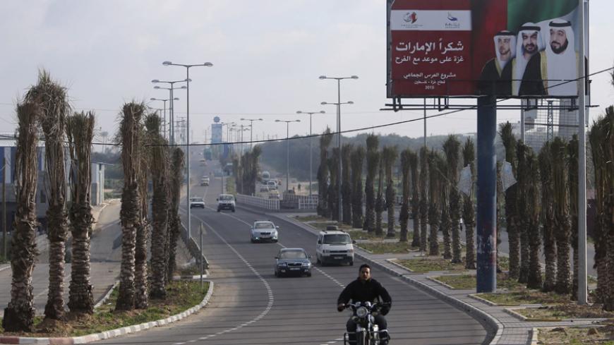 A Palestinian man rides his motorcycle past a billboard with pictures depicting UAE President Sheikh Khalifa bin Zayed al-Nahayan (R), Abu Dhabi Crown Prince Sheikh Mohammed bin Zayed (C) and UAE Deputy Prime Minister Sheikh Mansour bin Zayed al-Nahyan in Gaza City March 15, 2015. The billboard reads, "Thanks Emirates. Gaza is on a date for celebration. Mass wedding project." 
REUTERS/Ibraheem Abu Mustafa (GAZA - Tags: SOCIETY POLITICS) - RTR4TED7
