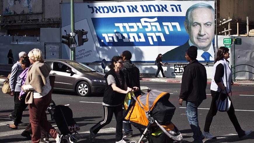 Pedestrians cross a street in front of a Likud party campaign billboard depicting Israeli Prime Minister Benjamin Netanyahu in Ramat Gan near Tel Aviv March 16, 2015. Netanyahu, in a final bid to shore up right-wing support ahead of a knife-edge vote on Tuesday, said he would not permit a Palestinian state to be created under his watch if he is re-elected. REUTERS/Nir Elias (ISRAEL - Tags: POLITICS ELECTIONS) - RTR4TKW3