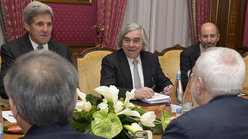 U.S. Secretary of State John Kerry (L) holds a meeting with Iran's Foreign Minister Javad Zarif (front R) over Iran's nuclear program in Lausanne March 17, 2015.  Also at the negotiating table is U.S. Secretary of Energy Ernest Moniz (C).  REUTERS/Brian Snyder   (SWITZERLAND - Tags: POLITICS ENERGY) - RTR4TMTE