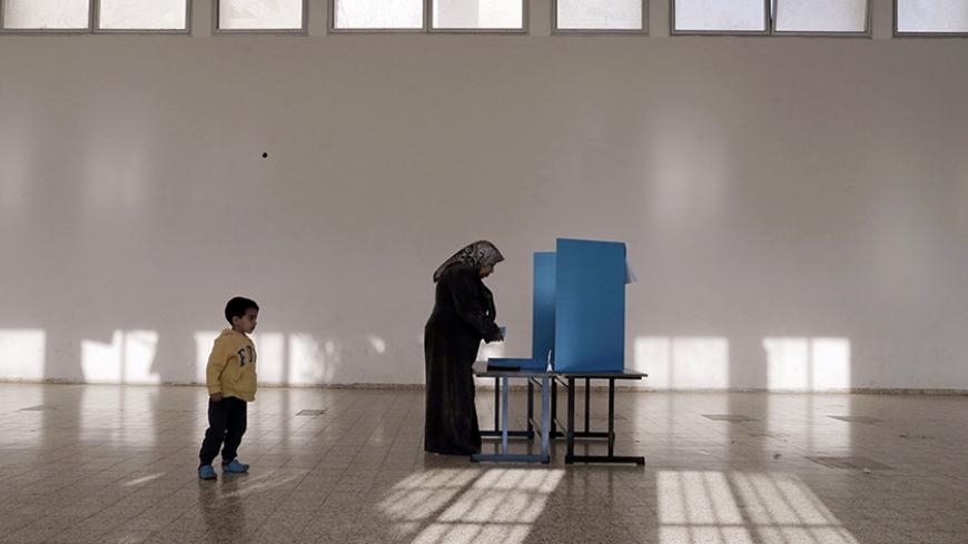 An Israeli Arab stands behind a voting booth before casting her ballot at a polling station in the northern town of Umm el-Fahm March 17, 2015. Millions of Israelis turned out to vote on Tuesday in a tightly-fought election, with Prime Minister Benjamin Netanyahu facing an uphill battle to defeat a strong campaign by the centre-left opposition to deny him a fourth term in office. In a possible sign of edginess, Netanyahu took to Facebook to denounce what he said was an effort by left-wing non-profit groups 