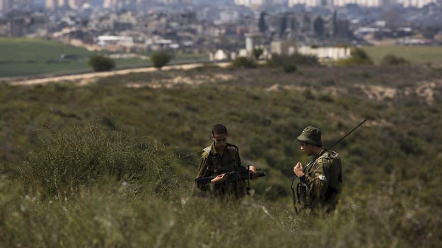 Israeli soldiers take part in a surprise drill near the border with the Gaza Strip (seen in the background), launched to maintain the readiness of the forces in the area, March 22, 2015. REUTERS/Amir Cohen  - RTR4UDRP