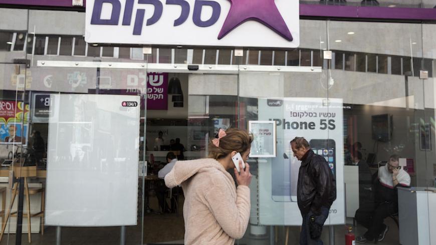 A woman walks past a branch of Israel's biggest mobile phone operator Cellcom in Tel Aviv January 28, 2014. Israeli conglomerates, including IDB Holding, will offload billions of dollars worth of assets over the next few years to comply with a new law designed to promote competition and dilute the power of big business in a country where a few tycoons control much of the economy. IDB Holding owns IDB Development, which in turn owns 74 percent of holding company Discount Investment Corp. Discount Investment 