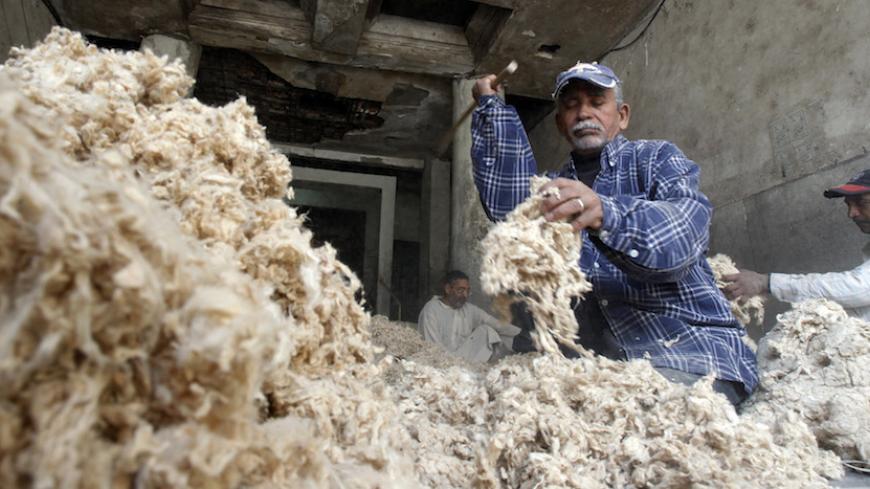 A cotton worker is pictured along a street in old Cairo November 27, 2010. Egyptians wondering whether to vote in Sunday's parliamentary election must factor in the risk of brawls involving thugs hired by rival candidates. REUTERS/Amr Abdallah Dalsh (EGYPT - Tags: POLITICS ELECTIONS) - RTXV4R6