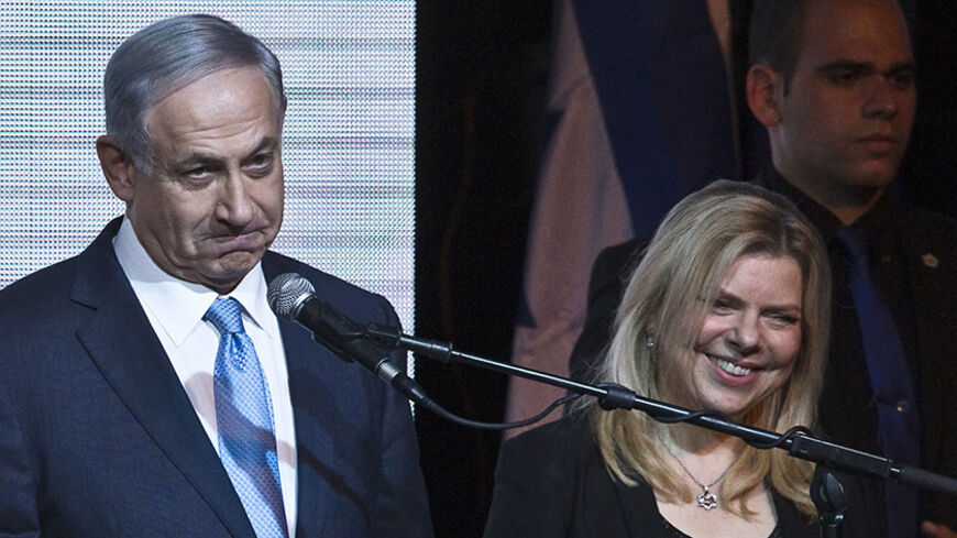 Israeli Prime Minister Benjamin Netanyahu stands next to his wife Sara as he delivers a speech to supporters at party headquarters in Tel Aviv March 18, 2015. Netanyahu claimed victory in Israel's election on Tuesday after exit polls showed he had erased his center-left rivals' lead with a hard rightward shift that saw him disavow a commitment to negotiate a Palestinian state. REUTERS/Nir Elias (ISRAEL - Tags: POLITICS ELECTIONS) - RTR4TRPI
