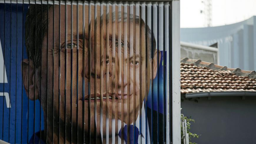 Israel's Prime Minister Benjamin Netanyahu (R) and Isaac Herzog, Co-leader of the centre-left Zionist Union, are pictured together as campaign billboards rotate in Tel Aviv, March 9, 2015. Israelis will vote in a parliamentary election on March 17, choosing among party lists of candidates to serve in the 120-seat Knesset. Currently, polls show Netanyahu's Likud party and the centre-left Zionist Union opposition running neck-and-neck, with each predicted to win around 24 seats in the Knesset. REUTERS/Baz Ra