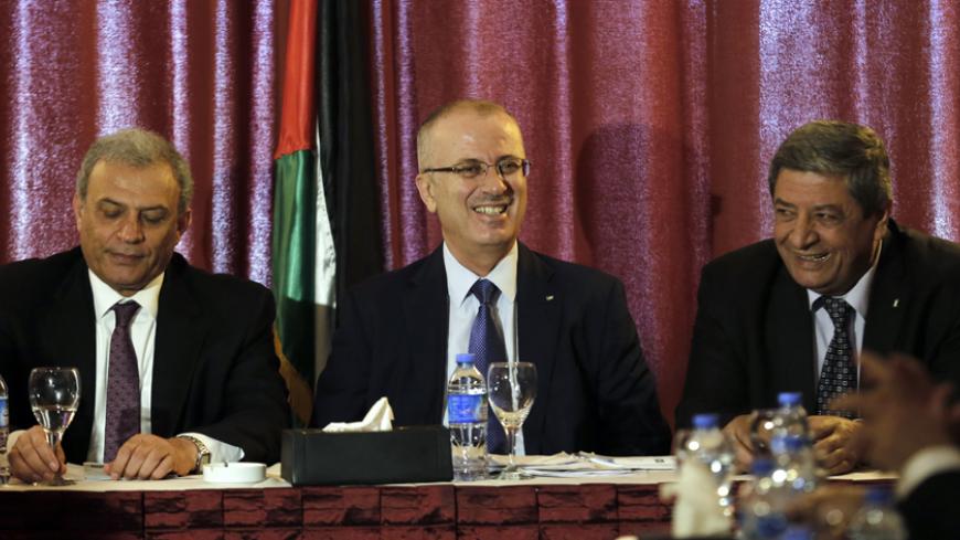 Palestinian prime minister Rami Hamdallah (C) sits next to deputy prime minister Ziad Abu Amr (L) and former minister al-Sharafi (R) during a meeting to discuss national reconciliation, on March 26, 2015 in Gaza City, in the Hamas-run Palestinian territory. Hamdallah urged rival factions to set aside their differences, even as protesters gave him a cool reception in war-battered Gaza. It was only Hamdallah's second visit to the Gaza Strip since a unity government agreed on by rivals Fatah and Hamas took off