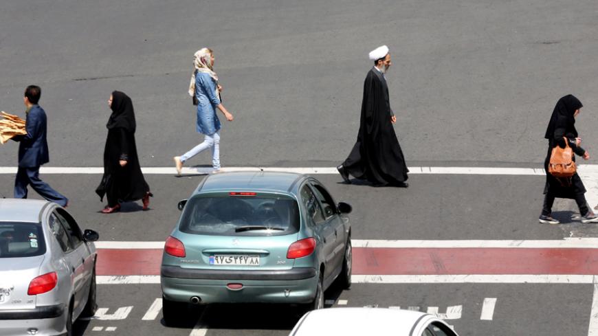 Iranians cross a road in Tehran on April 1, 2015. AFP PHOTO / ATTA KENARE        (Photo credit should read ATTA KENARE/AFP/Getty Images)