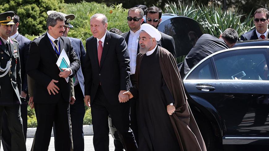 Iran's President Hassan Rouhani (R) holds hands with Turkish President Recep Tayyip Erdogan (C) as they walk during an official welcoming ceremony following the latter's arrival at the Saadabad Palace in Tehran on April 7, 2015, for an official one-day visit as the two countries criticized each other in recent weeks on their respective policies in the region. AFP PHOTO/ATTA KENARE        (Photo credit should read ATTA KENARE/AFP/Getty Images)