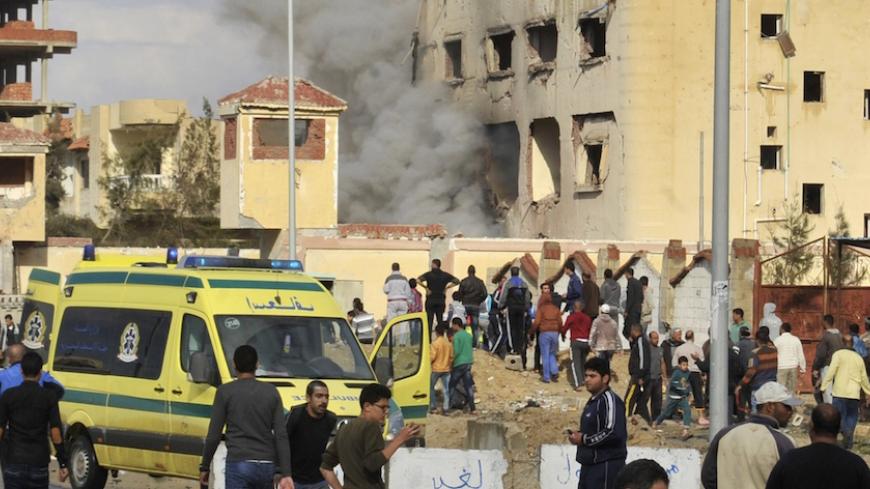 Egyptian residents and emergency personnel gather at the site of a car bomb explosion that targeted a police station in North Sinai's provincial capital of El-Arish on April 12, 2015. The bombing came hours after a roadside blast targeted an army vehicle killing at least six soldiers and wounding two in the peninsula, where security forces are battling an Islamist insurgency. AFP PHOTO / STR         (Photo credit should read -/AFP/Getty Images)