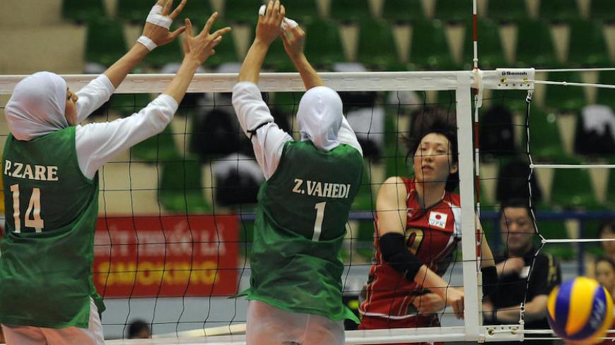 Japan's Ishida Mizuho (R) spikes the ball past Iran's Zare Pouran (L) and Vahedi Langroodi Zahra (C) during the Asian Senior Women's Volleyball championship quarter final between in Hanoi on September 11, 2009. Japan won 3-0 by 25-11, 25-6, 25-7 . AFP PHOTO/HOANG DINH Nam (Photo credit should read HOANG DINH NAM/AFP/Getty Images)