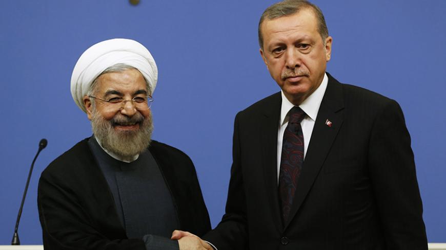 Iran's President Hassan Rouhani shakes hands with Turkish Prime Minister Tayyip Erdogan after a news conference in Ankara June 9, 2014. REUTERS/Umit Bektas (TURKEY - Tags: POLITICS) - RTR3SXID