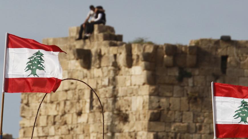 A couple sits over ruins in Sidon, south Lebanon, June 22, 2014. REUTERS/Ali Hashisho (LEBANON - Tags: SOCIETY) - RTR3V57S