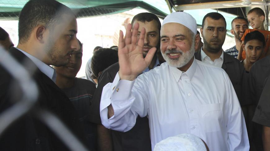 Senior Hamas leader Ismail Haniyeh waves after performing Friday prayers at a makeshift tent erected near the remains of a mosque, which witnesses said was hit by an Israeli air strike during a seven-week Israeli offensive, in Gaza City September 5, 2014. An open-ended ceasefire between Israel and Hamas-led Gaza militants, mediated by Egypt, took effect on August 26 after a seven-week conflict. It called for an indefinite halt to hostilities, the immediate opening of Gaza's blockaded crossings with Israel a