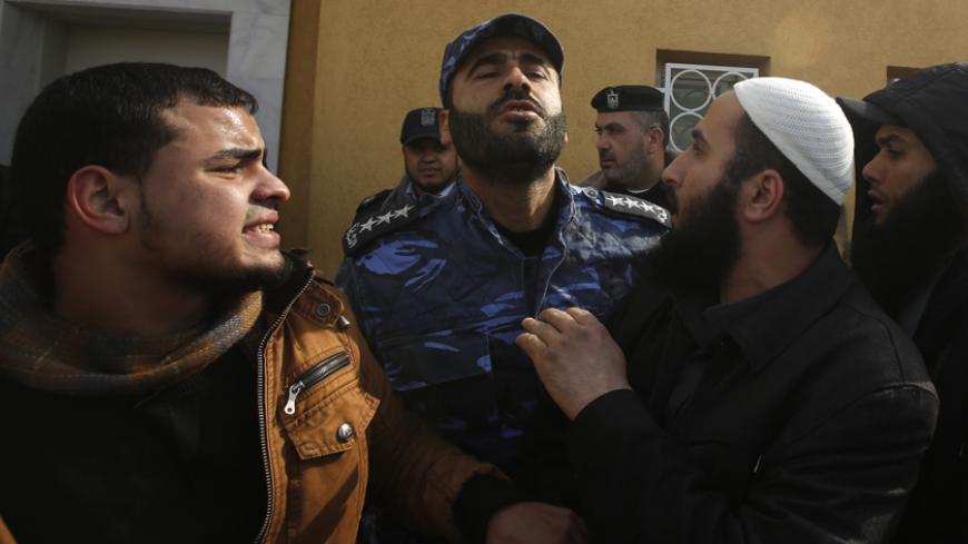 A Palestinian police officer loyal to Hamas pushes back Salafists during a protest against satirical French weekly magazine Charlie Hebdo's cartoons of the Prophet Mohammad, outside the French Cultural Centre in Gaza city January 19, 2015. Dozens of Jihadist Salafi men rallied in Gaza on Monday to condemn continued publication by French satirical magazine Charlie Hebdo of cartoons deemed offensive to Islam's Prophet. Charlie Hebdo published a picture of Mohammad weeping on its cover last week after gunmen s