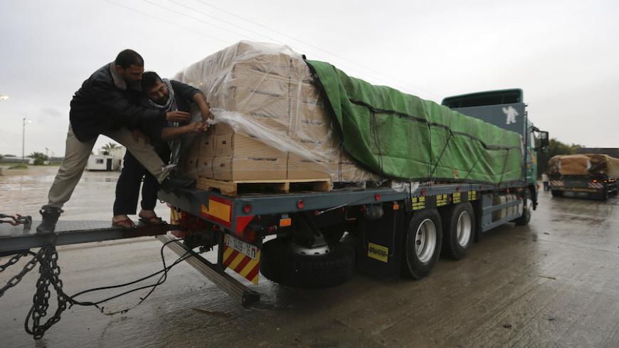 Palestinians cover cartons containing vegetables before exporting them to Israel, at the Kerem Shalom crossing in Rafah in the southern Gaza Strip  March 12, 2015. Israel imported its first fruit and vegetables from the Gaza Strip in almost eight years on Thursday, in a partial easing of an economic blockade maintained since the Islamist group Hamas seized control of the Palestinian territory. Twenty-seven tonnes of tomatoes and five tonnes of eggplants were trucked across the border under an Israeli plan t